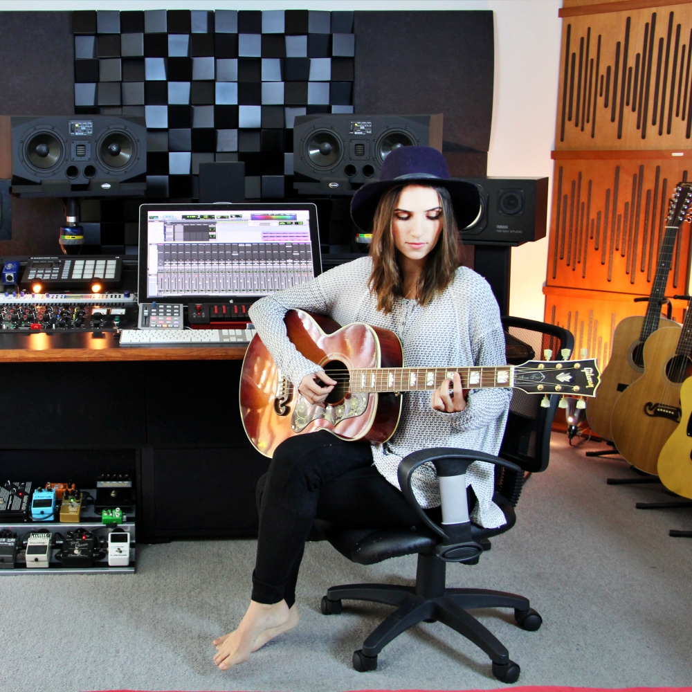 Ragazza che suona la chitarra nel suo home studio